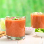 Traditional Spanish cold vegetable soup made of tomato, cucumber, bell pepper, onion, garlic and olive oil served in glasses (Selective Focus, Focus on the front of the glass rim)